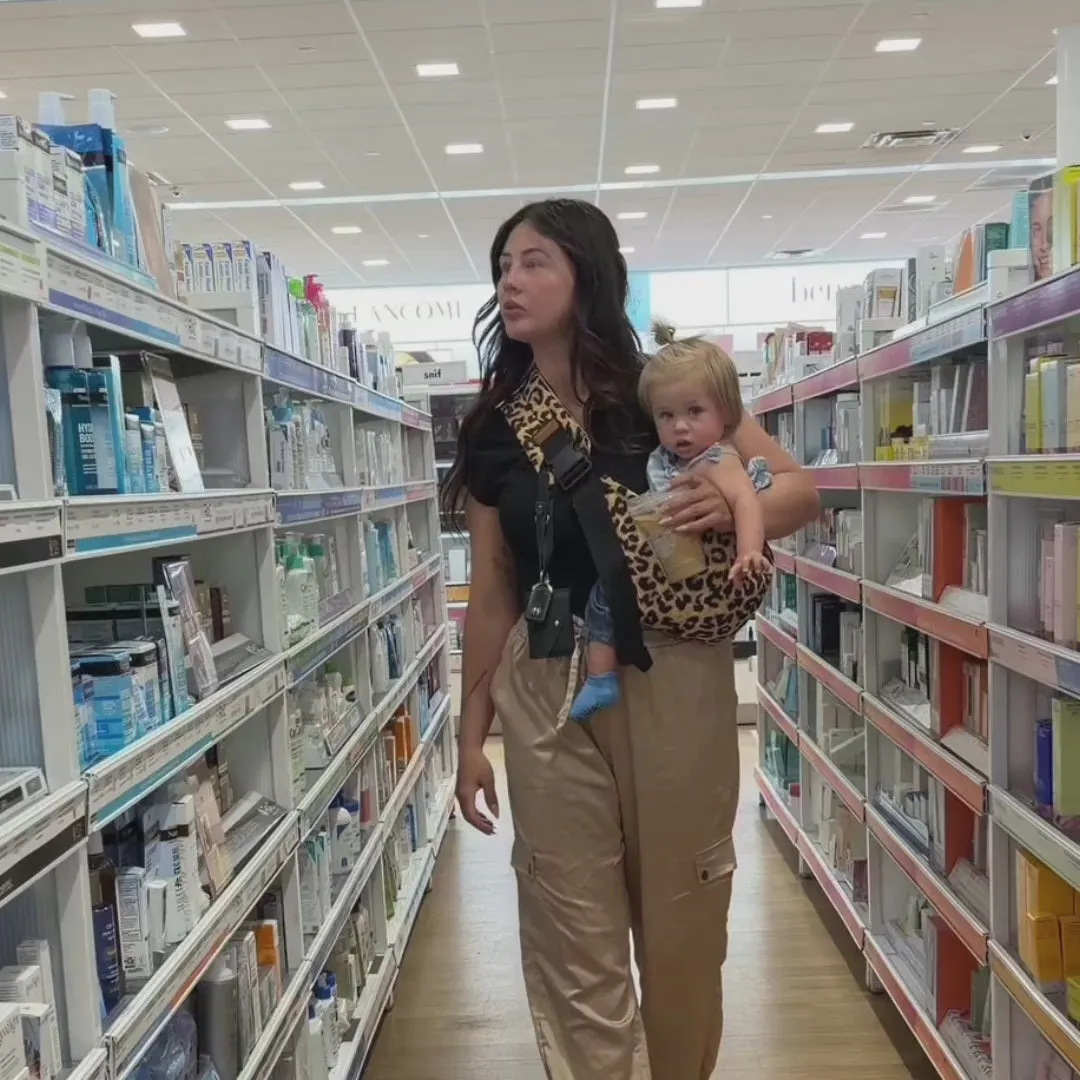 Parent shopping with baby in sling